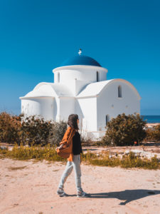 Beautiful young girl in front of classical blue and white Greek